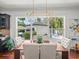 Bright dining room with hardwood floors, modern chandelier, and view to backyard pool at 124 Estado Ne Way, St Petersburg, FL 33704