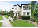 A meticulously landscaped home features a covered balcony, manicured lawn, and mature trees at 124 Estado Ne Way, St Petersburg, FL 33704