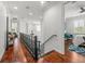 Bright hallway with wood floors, decorative railing and a view into other rooms at 124 Estado Ne Way, St Petersburg, FL 33704