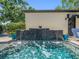 Beautiful swimming pool with a decorative tile waterfall feature and lush landscaping at 124 Estado Ne Way, St Petersburg, FL 33704