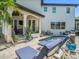 Private backyard pool with elegant stone patio, surrounded by lush landscaping and comfortable lounge seating at 124 Estado Ne Way, St Petersburg, FL 33704