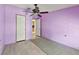 Neutral bedroom with a ceiling fan, neutral rug, and two doors at 12502 Tocci Ln, Riverview, FL 33579