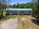 Rear exterior of property with two entrances, stairs, and blue roof at 12502 Tocci Ln, Riverview, FL 33579