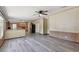 Open living room with wood-look floors, a ceiling fan, and an open kitchen at 12502 Tocci Ln, Riverview, FL 33579