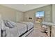 Well-lit bedroom with neutral tones, a comfortable bed, and a dedicated desk area at 12950 Pasture Woods Pl, Lithia, FL 33547