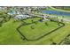 Expansive fenced dog park with lush green grass and shaded seating area, perfect for pets to play and socialize at 12950 Pasture Woods Pl, Lithia, FL 33547