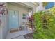 Inviting front porch with a charming, light-blue door and a welcoming gnome sign and 'Welcome' doormat at 12950 Pasture Woods Pl, Lithia, FL 33547