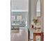Hallway with wood floors leading into a living room with a comfy sectional couch and a view of windows at 12950 Pasture Woods Pl, Lithia, FL 33547