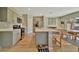 Bright kitchen with stainless steel appliances, gray cabinets, and an island with bar seating open to dining area at 12950 Pasture Woods Pl, Lithia, FL 33547