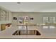 Modern kitchen with stainless steel sink and an open floor plan into the dining area at 12950 Pasture Woods Pl, Lithia, FL 33547