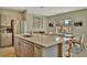 Modern kitchen with stainless steel appliances and a large island with seating that opens to dining area at 12950 Pasture Woods Pl, Lithia, FL 33547