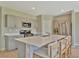 Well-lit kitchen featuring gray cabinets, stainless steel appliances, and a large island with seating at 12950 Pasture Woods Pl, Lithia, FL 33547