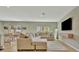 Spacious living room with a large sectional sofa, mounted TV, and an open dining area at 12950 Pasture Woods Pl, Lithia, FL 33547