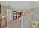 Inviting loft area featuring a cozy reading nook with built-in bookcases and neutral carpeting at 12950 Pasture Woods Pl, Lithia, FL 33547