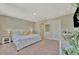 Bright and airy main bedroom with a large bed, neutral carpet, and a modern decor at 12950 Pasture Woods Pl, Lithia, FL 33547
