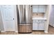 This kitchen features a stainless steel refrigerator with bright white cabinets and a tile floor at 13653 Artesa Bell Dr, Riverview, FL 33579