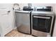A laundry room with a gray front load washer and dryer set with a tile floor at 13653 Artesa Bell Dr, Riverview, FL 33579