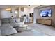 Open concept living room with neutral sectional sofa, tv and kitchen bar seating at 13653 Artesa Bell Dr, Riverview, FL 33579