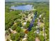 Aerial view showcases the property's location, surrounded by a canal, mature trees and a lake in the distance at 1407 Jean St, Lutz, FL 33548