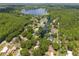 Aerial view showcasing a neighborhood along a canal with lake access, surrounded by trees at 1407 Jean St, Lutz, FL 33548