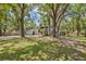 Spacious backyard with a volleyball court, swing set, and plenty of shade trees at 1407 Jean St, Lutz, FL 33548