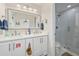 Bright bathroom with double sinks, a large mirror and a glass-enclosed shower with subway tile at 1407 Jean St, Lutz, FL 33548