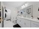 Bright bathroom with a double sink vanity, quartz countertops, a toilet, and stylish decor at 1407 Jean St, Lutz, FL 33548
