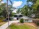 Charming two-story home with landscaped yard, long driveway, and mature trees creates a welcoming curb appeal at 1407 Jean St, Lutz, FL 33548