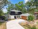 Charming two-story home with landscaped yard, long driveway, basketball hoop, and mature trees creates curb appeal at 1407 Jean St, Lutz, FL 33548