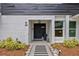 An inviting front entrance with a modern black door, well-maintained landscaping and charming walkway enhances curb appeal at 1407 Jean St, Lutz, FL 33548