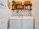 Cozy laundry room with a washer, dryer, decorative shelves, and stylish decor at 1407 Jean St, Lutz, FL 33548