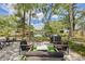 Beautiful brick patio with comfortable seating, lush landscaping, string lights, and lake views at 1407 Jean St, Lutz, FL 33548