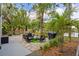Landscaped brick patio has a seating area and grill near lush foliage and tropical palm trees at 1407 Jean St, Lutz, FL 33548