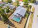 Aerial view of home featuring a screened-in pool, fenced yard, and mature trees at 1501 Wisconsin Ave, Palm Harbor, FL 34683