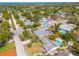 Aerial view of a home with a screened-in patio and pool, surrounded by mature trees and lush landscaping in a quiet neighborhood at 1501 Wisconsin Ave, Palm Harbor, FL 34683