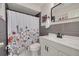 Stylish bathroom with white vanity, dark gray tiling, and a patterned shower curtain at 1501 Wisconsin Ave, Palm Harbor, FL 34683