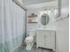 Bright bathroom features white vanity, oval mirror, and updated fixtures at 1501 Wisconsin Ave, Palm Harbor, FL 34683