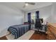 Cozy bedroom features a ceiling fan, hardwood floors, and natural light from the window at 1501 Wisconsin Ave, Palm Harbor, FL 34683