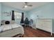 Inviting bedroom features a ceiling fan, wood floors, and a black out curtains at 1501 Wisconsin Ave, Palm Harbor, FL 34683