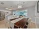 Open dining area with a rustic wooden table, modern lighting, and seamless transition to the adjacent kitchen and living spaces at 1501 Wisconsin Ave, Palm Harbor, FL 34683