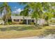 Charming single-story home featuring lush landscaping, mature trees, and a well-maintained lawn in a desirable neighborhood at 1501 Wisconsin Ave, Palm Harbor, FL 34683