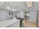 Bright kitchen with white cabinets, quartz countertops, and stainless steel appliances, open to the dining and living areas at 1501 Wisconsin Ave, Palm Harbor, FL 34683