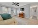 Bright living room with light walls and floors featuring a comfortable couch, accent pillows, and a classic wood cabinet at 1501 Wisconsin Ave, Palm Harbor, FL 34683