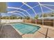A beautiful screened-in pool area is showcased with brick pavers surrounding the pool at 1501 Wisconsin Ave, Palm Harbor, FL 34683