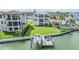 Aerial shot of a waterfront property with a lush green lawn, private dock, and boat lift perfect for boaters at 16025 Redington Dr, Redington Beach, FL 33708