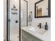 Modern bathroom featuring a walk-in shower with black fixtures and a stylish vanity with marble countertop at 16025 Redington Dr, Redington Beach, FL 33708