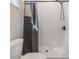 White tiled shower with grey curtain and black shower head in bathroom at 16025 Redington Dr, Redington Beach, FL 33708