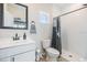 Bathroom with modern sink and vanity, toilet, and tile shower with curtain at 16025 Redington Dr, Redington Beach, FL 33708