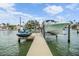 A private boat lift and dock ready for boating adventures under the beautiful open sky and clear water at 16025 Redington Dr, Redington Beach, FL 33708