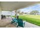 A covered patio with comfortable seating overlooking a spacious, well-maintained backyard and waterfront at 16025 Redington Dr, Redington Beach, FL 33708